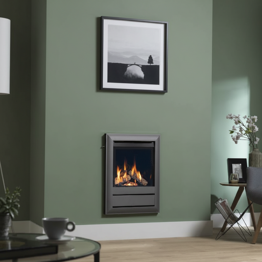 A modern wall-mounted electric fireplace with a dark gray frame and glowing orange flames, set into a sage green wall in a living room setting.