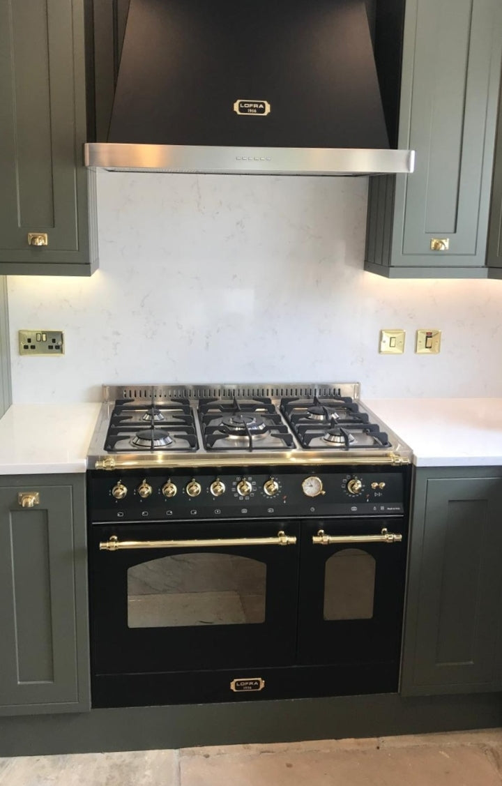 Modern kitchen with black Lofra Gemella 90 Gas Integrated fitting and hood against a gray backsplash.