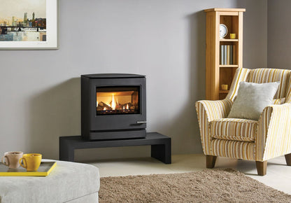 Modern living room with a black Gazco Yeomann CL8 freestanding stove, striped armchair, and bookshelf.