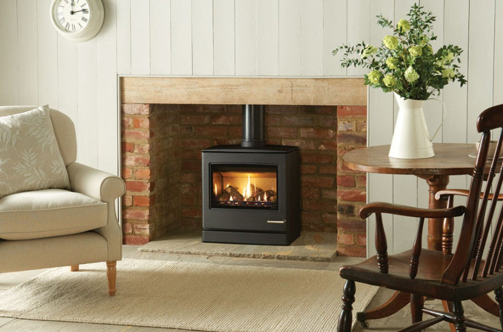 Living room with a fireplace, armchair, and wooden chair with Gazco CL8 Balanced Flue Gas Stove – High Efficiency Log Effect Gas Stove