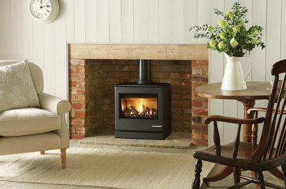 Living room with a fireplace, armchair, and wooden chair with Gazco CL8 Balanced Flue Gas Stove – High Efficiency Log Effect Gas Stove