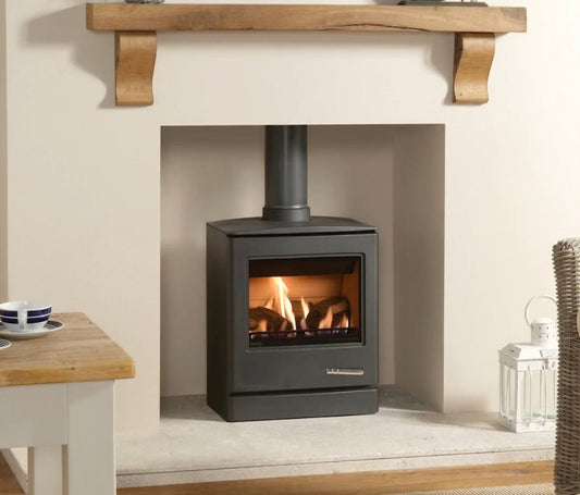 Modern Yoeman Cl5 Gas Stove in a fireplace with wooden mantel and table.