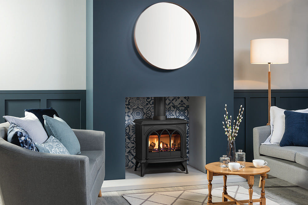 Gazco Huntingdon 40 Warm Blue Tone Living room with gray sofa, round mirror, and wooden coffee table.