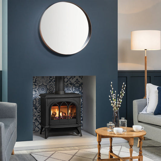 Gazco Huntingdon 40 Warm Blie Tone Living room with gray sofa, round mirror, and wooden coffee table.