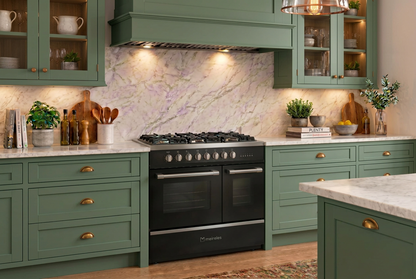 A black Lisbon freestanding gas duel fuel range range cooker with multiple knobs and a digital control panel, set in a modern kitchen with light gray cabinets, white marble countertops, and gold handles.     