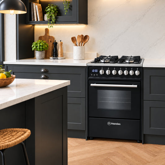 A black Miereles gas range cooker installed in a modern kitchen with dark charcoal cabinets, white marble countertops, and warm pendant lighting.