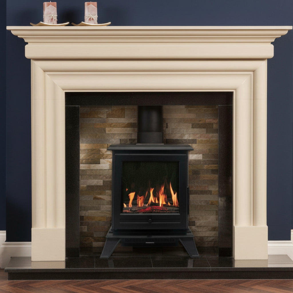 A cream-colored stone fireplace surround with a black electric wood-burning Trance 500 Freestanding Stove , set against a dark navy blue wall and above a dark hearth with a wood floor.