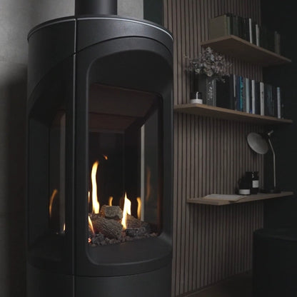 Modern black fireplace with flames inside, next to a wooden shelf with decorative items from the Onyx Liv 3 Gas Stove High Efficiency Gas Stove Ireland Contemporary Log Effect Gas Stove