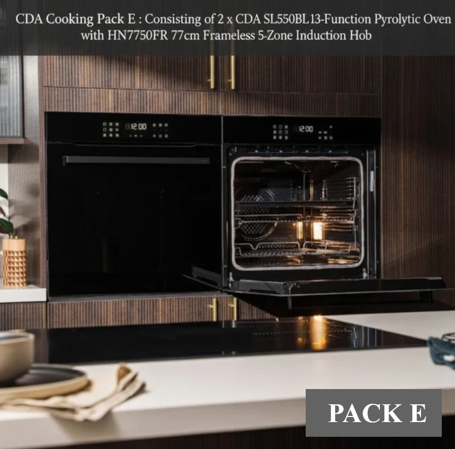 Black built-in double oven cooking pack installed in a modern kitchen with dark wood cabinets and a white countertop. One oven door is open, showing the interior racks and lit cooking chamber.
