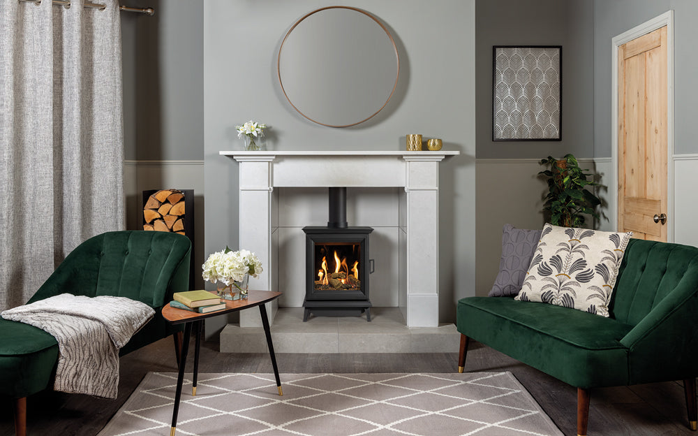 Gazco Sheraton Gas Stove in Living room with green sofa, fireplace, and decorative elements.