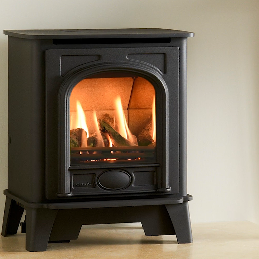 Black freestanding Gazco Small Stockton Gas stove with flames inside on a beige background