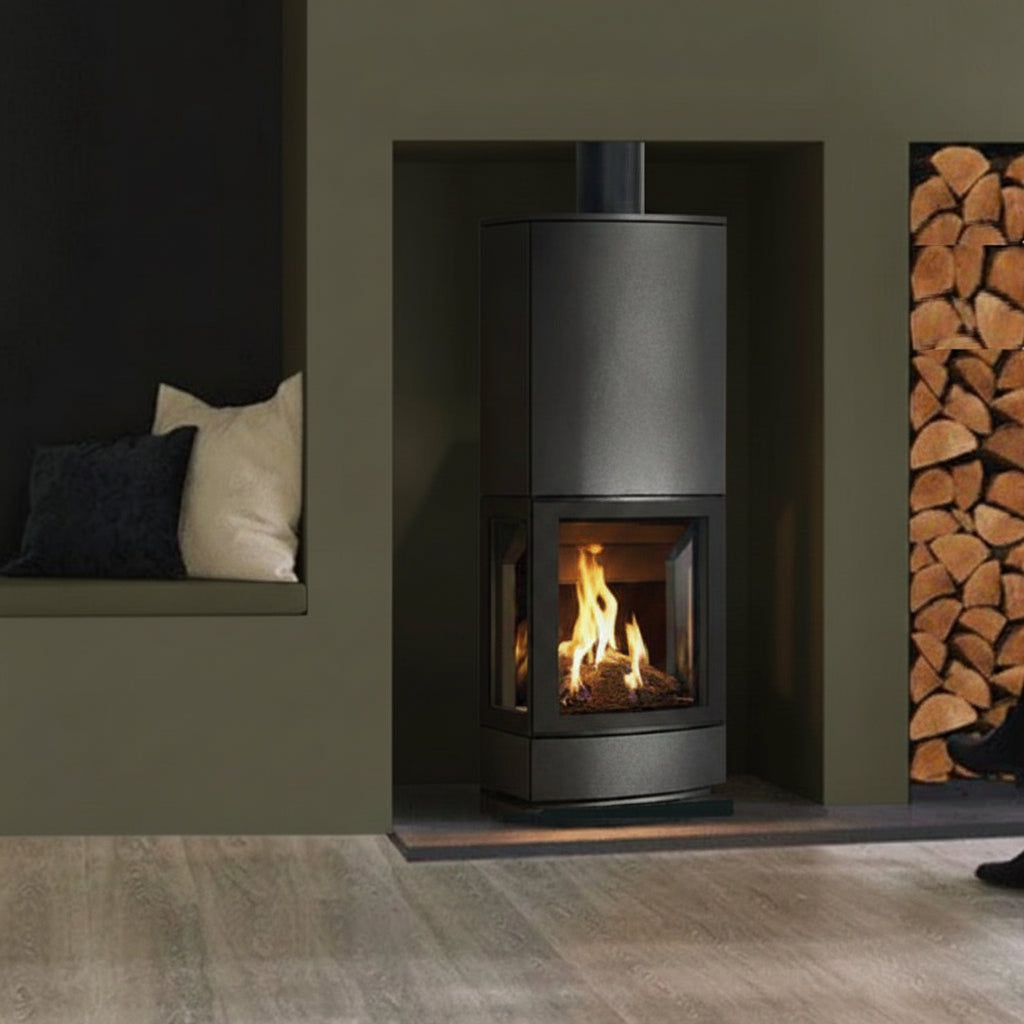 Modern Gazco Loft freestanding gas stove with visible flames in a room with dark olive walls and wooden logs.