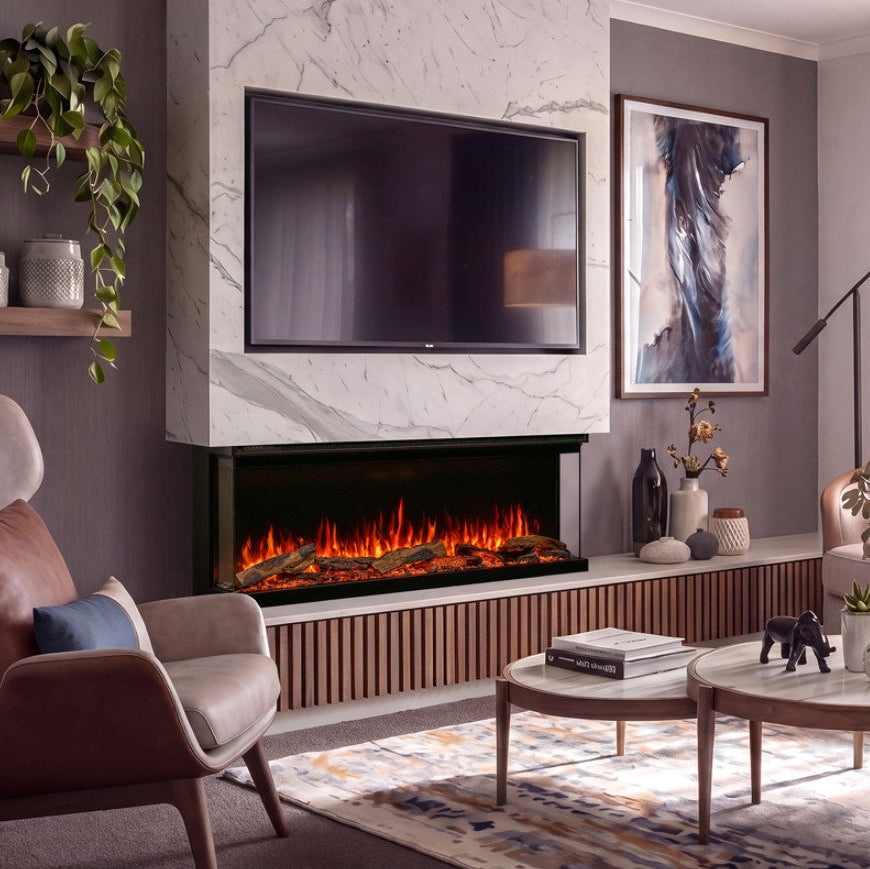 A modern wall-mounted electric Atmos Fire FX Versa fireplace with glowing orange flames, set into a white marble-look panel above a slatted wood console in a styled living room with a TV, chairs, and coffee tables.