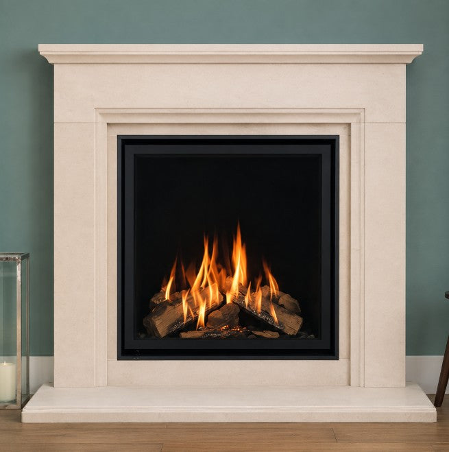 Wildfire Ravel 750 HE Log Effect Slide Control Chimney Gas FireWhite fireplace with a lit fire inside against a teal wall.