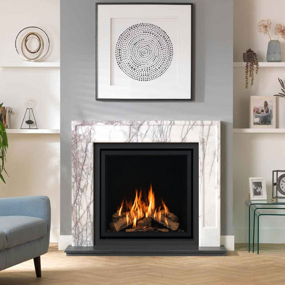 Wildfire Ravel 750 HE Log Effect Slide Control Chimney Gas Fire with Edge Trim in Modern White Italian marble fireplace surround in a living room setting