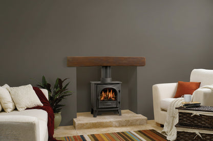 Gazco Stockton 5 Balanced Flue Gas Stove in cream sofa Living room with a fireplace, sofa, and striped rug.